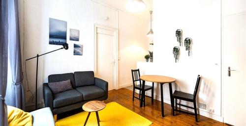 un salon avec un canapé et une table dans l'établissement L'impressionniste-Charme de l'ancien-Hypercentre, à Nantes