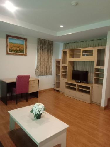 a living room with a table and a tv at NOP PLACE BANGNA in Ban Bang Phrao