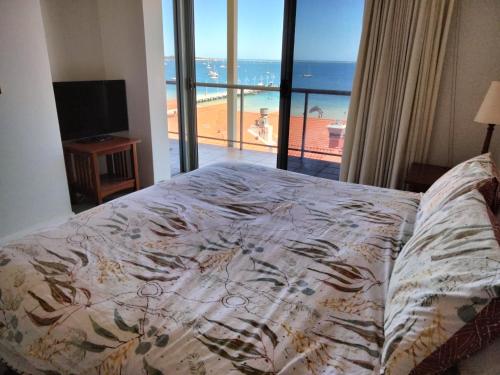 a bedroom with a bed with a view of the ocean at The Boardwalk Apartment in Rockingham