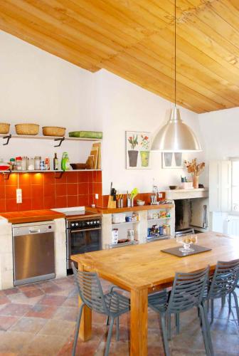 une cuisine avec une table et des chaises en bois dans l'établissement Les Tourelles, à Uzès