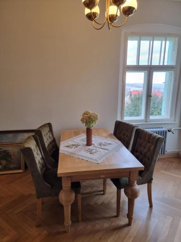 a dining room table with chairs and a vase on it at Sienkiewicza 4 in Złoty Stok