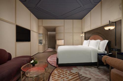a hotel room with a bed and a couch at Hotel Indigo Wuxi Taihu New City in Wuxi