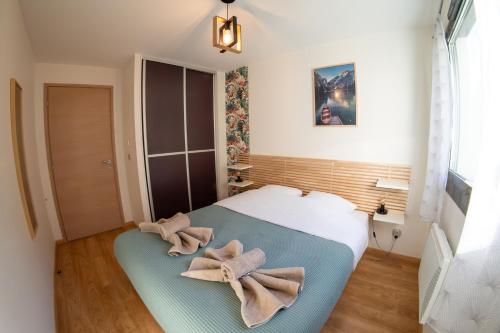 1 dormitorio con 1 cama con toallas en Le Reflet du Lac, en Sévrier