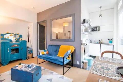 un salon avec un canapé bleu et une cuisine dans l'établissement «AU VINCI BLEU» Cosy - Centre-ville Amboise, à Amboise