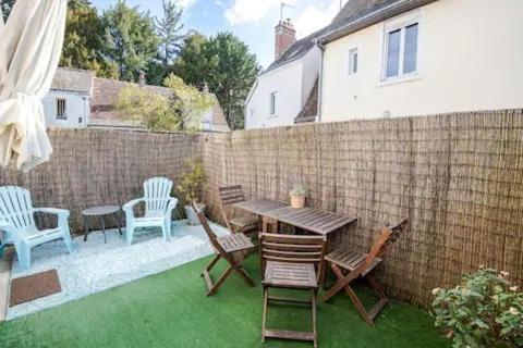 une cour avec une table, des chaises et une clôture dans l'établissement «AU VINCI BLEU» Cosy - Centre-ville Amboise, à Amboise