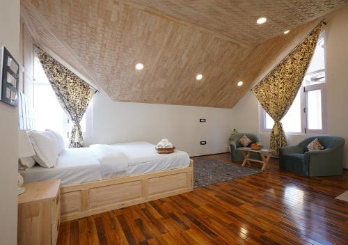 1 dormitorio con 1 cama grande y 2 sillas en Moustache Srinagar en Srinagar