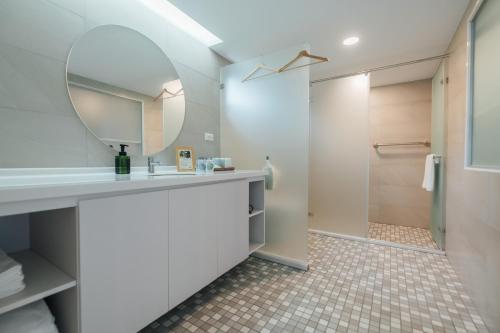 a bathroom with a sink and a mirror and a shower at 蘊慢築 茶花藝主題民宿 Yun Man Zhu Homestay in Gongguan