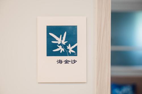a sign on a door with a picture of flowers at 蘊慢築 茶花藝主題民宿 Yun Man Zhu Homestay in Gongguan