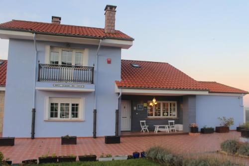 une maison blanche avec un toit rouge dans l'établissement Hotel Mirador del Sella, à Ribadesella