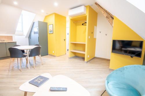 - un salon avec des murs jaunes, une table et des chaises dans l'établissement 4point1 - T3 pour 4pers., à Amboise
