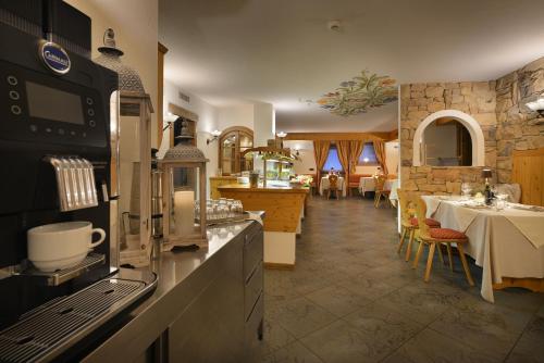 una cucina con piano cottura e una sala da pranzo con tavoli di Hotel Primula a Livigno