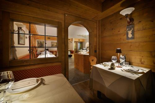 ein Esszimmer mit einem Tisch und einem Spiegel in der Unterkunft Hotel Primula in Livigno