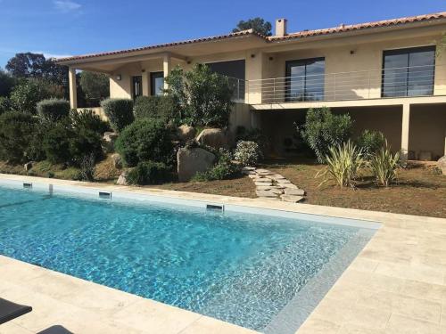 une maison avec une piscine devant une maison dans l'établissement Villa Testa contemporaine, 8 pers, vue mer, piscine, plage à pied, à Olmucciu