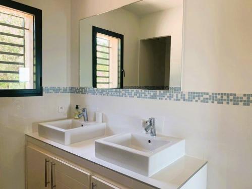 une salle de bain avec deux lavabos et un miroir dans l'établissement Villa Testa contemporaine, 8 pers, vue mer, piscine, plage à pied, à Olmucciu