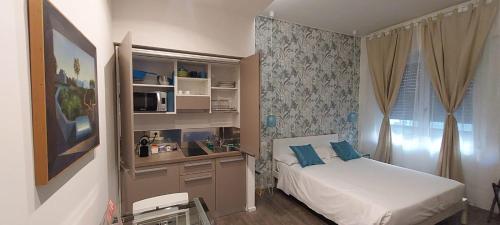 Schlafzimmer mit einem Bett und einem Schreibtisch mit einer Mikrowelle in der Unterkunft Marcona24 in Mailand