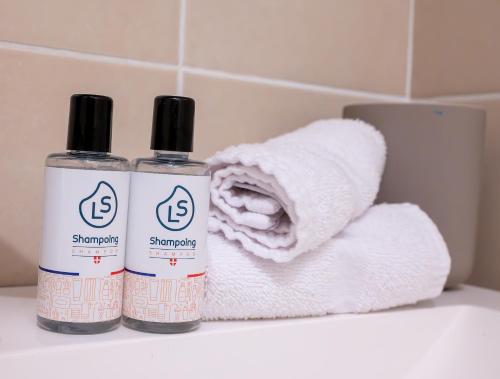 - deux bouteilles de shampoing et un tas de serviettes dans l'établissement Le Reflet du Lac, à Sévrier