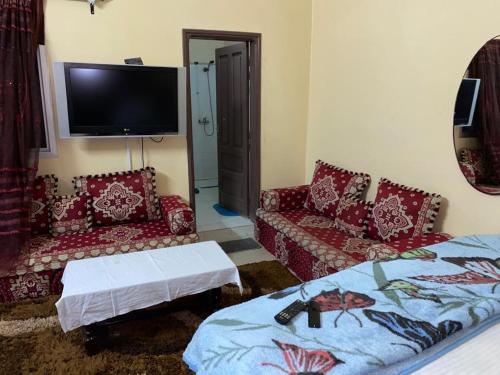 uma sala de estar com um sofá e uma televisão em Appartement Ngor Almadie em Dakar
