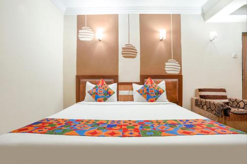 um quarto com uma cama com uma colcha colorida em FabHotel Shanti Sadan Near Ellisbridge em Ahmedabad