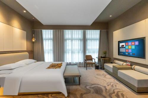 um quarto com uma grande cama branca e um sofá em Horgos Golden International Hotel em Kurgash