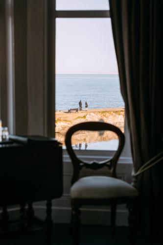 a chair in a room with a view of the ocean at The Nines in Bangor