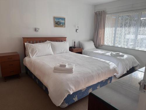 1 dormitorio con 2 camas y ventana en Hop, Skip & Jump From Picton Waterfront, en Picton