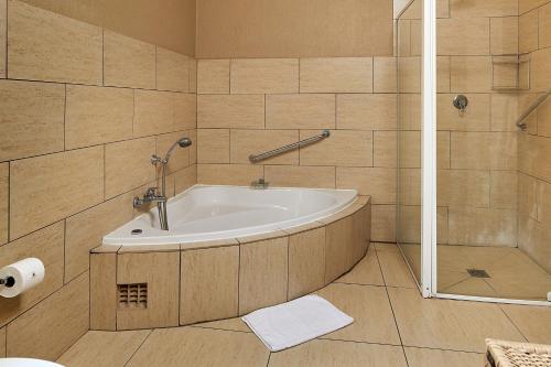 a bathroom with a bath tub and a shower at Waterberry Hill in Hazyview