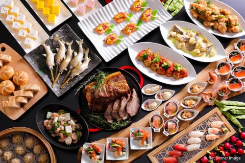 a table full of different types of food on plates at Hida Takayama Onsen Takayama Green Hotel - KEIO GROUP HOTELS - in Takayama