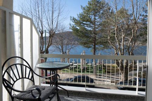a table and chair on a balcony with a view at Panagiotidis lake house in Kastoria