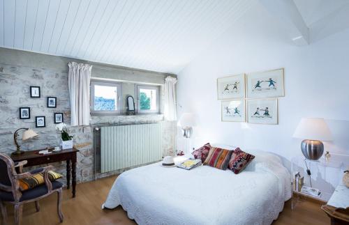 ein Schlafzimmer mit einem weißen Bett und einem Stuhl in der Unterkunft Villa Marcelline in Saint-Marcellin-lès-Vaison