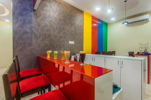 une cuisine colorée avec une table et des chaises rouges dans l'établissement Arton Regency, à Mumbai