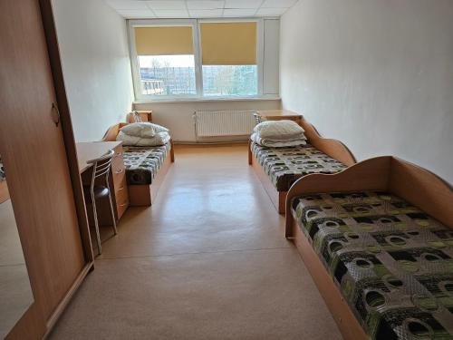 um quarto de hospital com duas camas e um lavatório em Kėdainių profesinio rengimo centras em Kėdainiai
