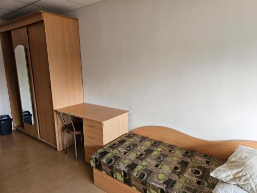 a bedroom with a bed and a dresser and a desk at Kėdainių profesinio rengimo centras in Kėdainiai
