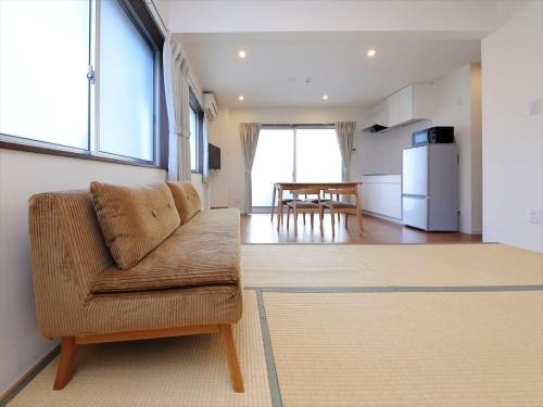 a living room with a couch and a kitchen at COTO Tokyo Shibuya 4 in Tokyo