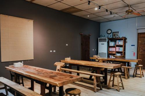 a room with wooden tables and chairs and a refrigerator at 蘊慢築 茶花藝主題民宿 Yun Man Zhu Homestay in Gongguan