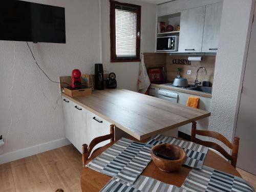eine Küche mit einem Holztisch im Zimmer in der Unterkunft Appartement en résidence proche du plan d'eau in Embrun