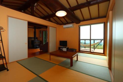 a living room with a table and a window at Yuushin in Mifune