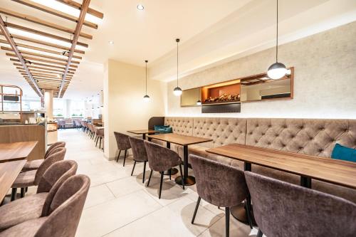 a restaurant with wooden tables and chairs at Hotel Lokomotive in Linz