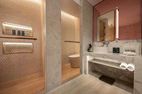 a bathroom with a sink and a toilet at Hotel Indigo Wuxi Taihu New City in Wuxi