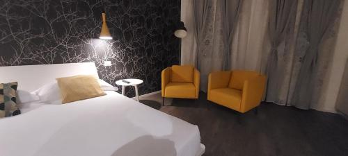 a hotel room with a bed and two chairs at Marcona24 in Milan