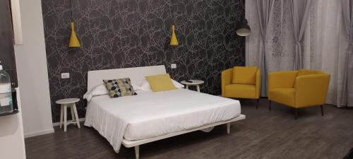 a bedroom with a bed and two yellow chairs at Marcona24 in Milan