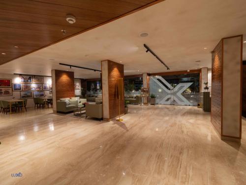 a large room with a wooden floor and a living room at Luxo Kochi in Ernakulam
