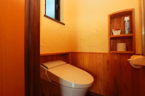 a small bathroom with a toilet and a mirror at Yuushin in Mifune