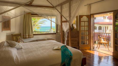 a bedroom with a bed and a view of the ocean at Kobe Suite Resort in Watamu