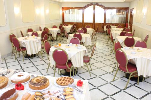 a room filled with tables and chairs with cakes and pastries at Hotel Romulus in Rome
