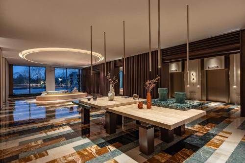a bathroom with two tables and a tub at Hotel Indigo Wuxi Taihu New City in Wuxi
