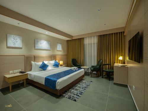 埃爾納古勒姆的住宿－Luxo Kochi，酒店客房,配有床和电视