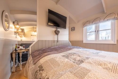 a bedroom with a large bed with a tv on the wall at Barleywood in South Creake