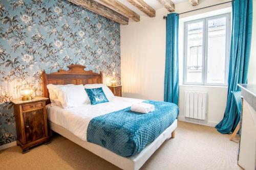 a bedroom with a bed with blue walls and a window at Maison paradisiaque avec piscine in Mosnes