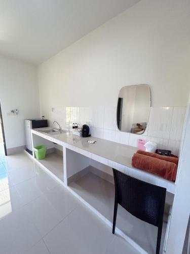 a white bathroom with a sink and a mirror at FairHouse khaolak in Khao Lak