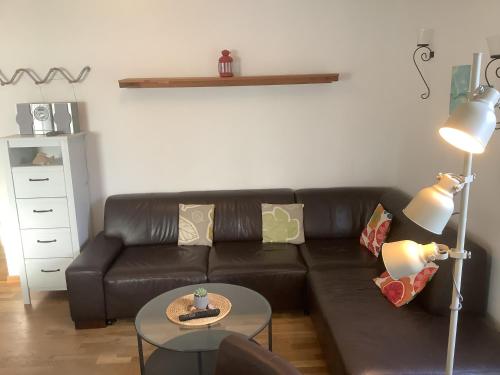 a living room with a black leather couch and a table at Pension Villa Wolkenlos in Dahme